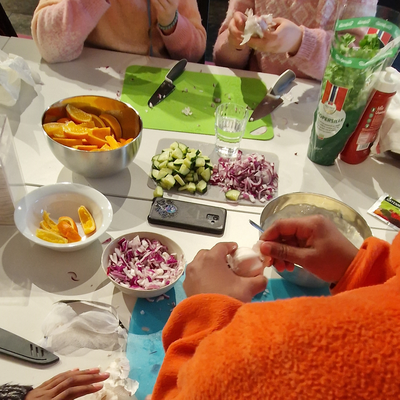 Et bord fylt med forskjellig mat, og barn som sitter rundt.